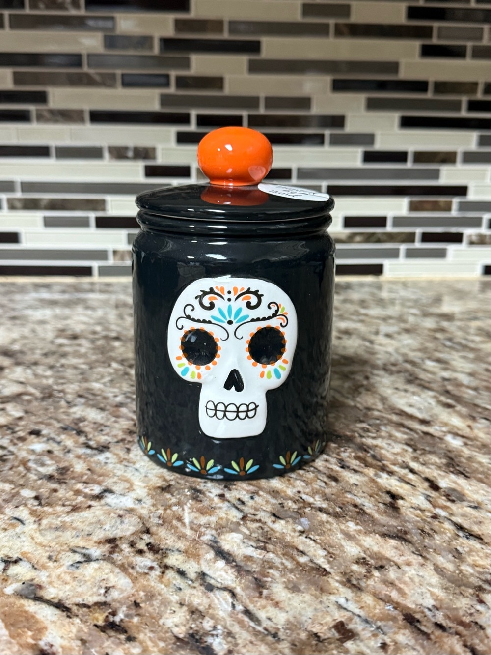 Black Ceramic Canister with Orange Lid and Decorative Skull Accent